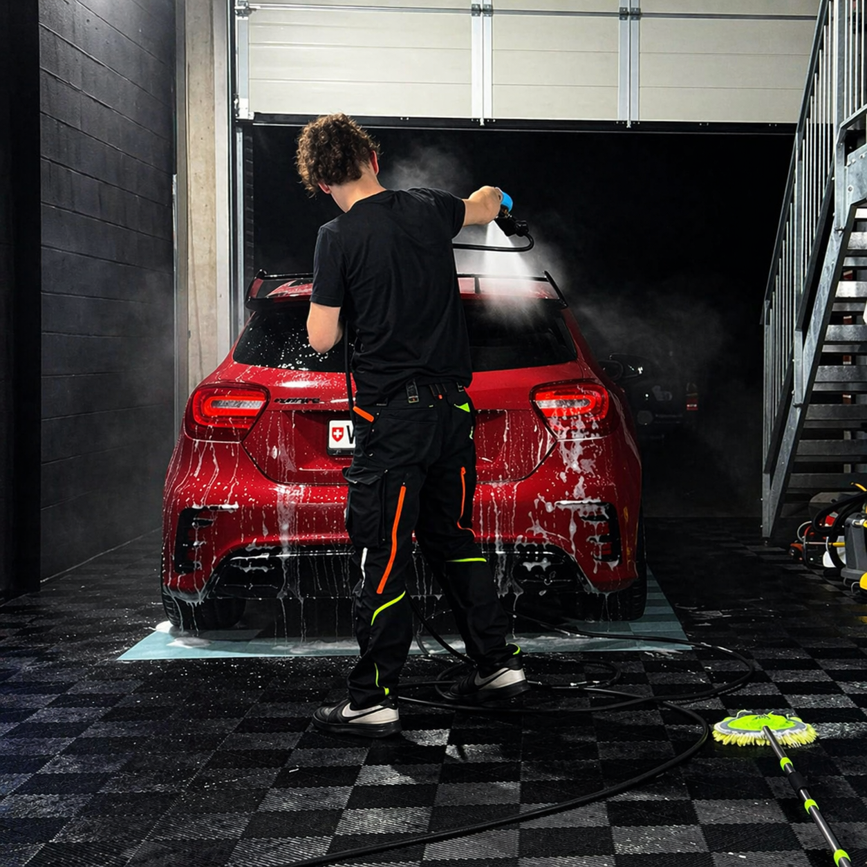 Voiture sport rouge en cours de detailing dans l'atelier Spec Center à Palézieux